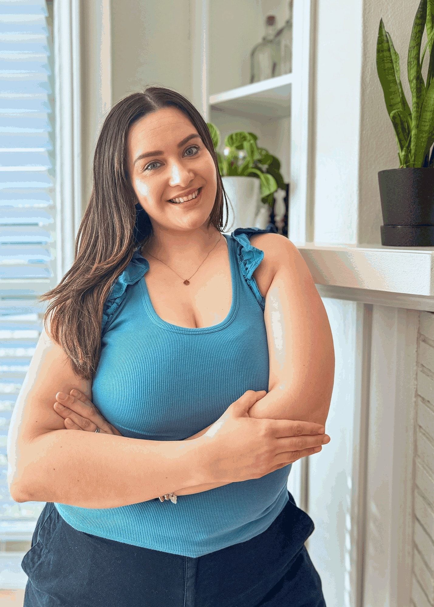 Mayra Ruelas-Ramirez, smiling with her arms crossed in her office